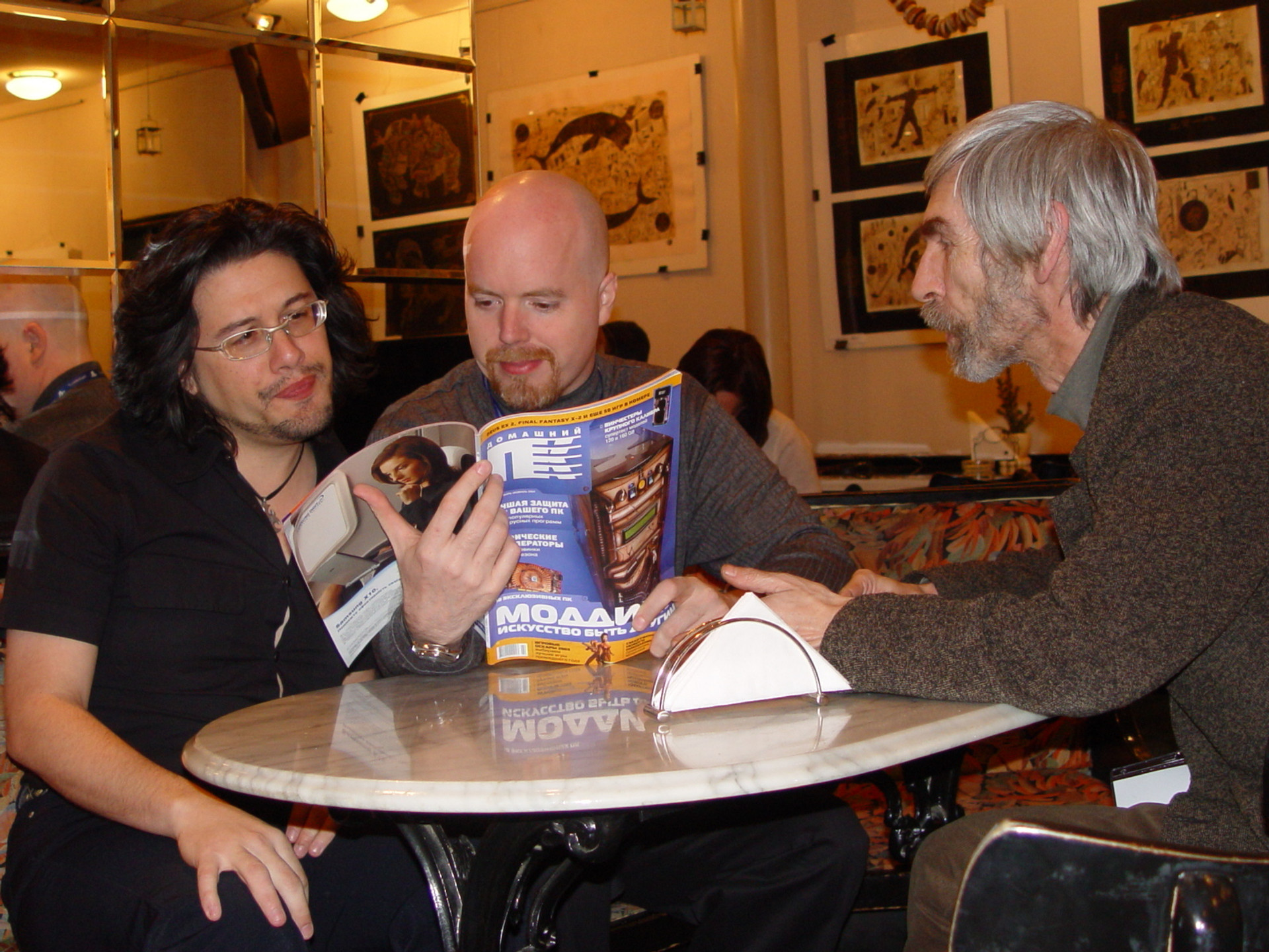 John Romero, Tom Hall, Alex Ptitsya and the latest issue of the DPK. It seems Hall likes what he reads. 2004, photo by the author
